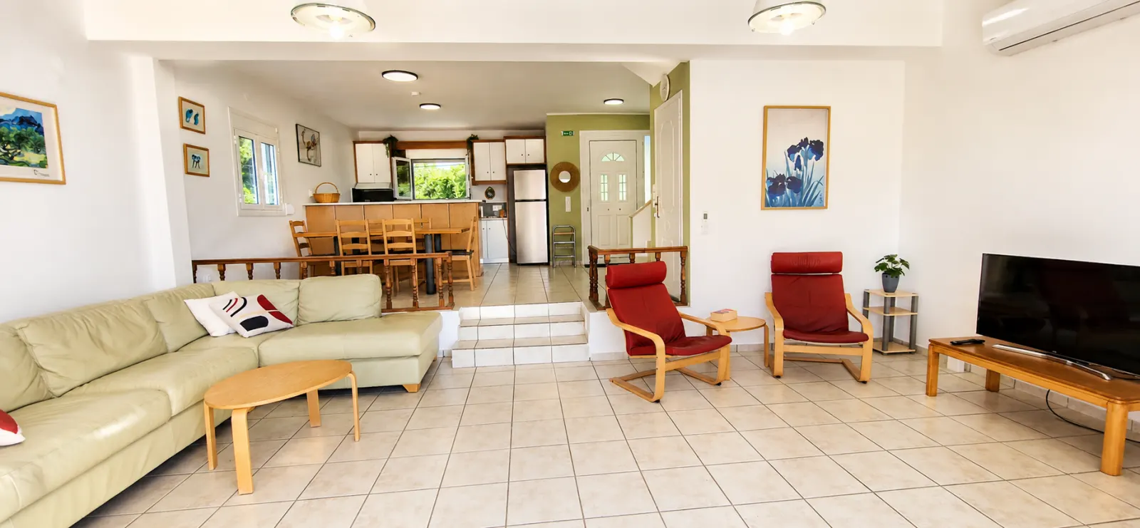 Open-plan living room with sofas, dining area and kitchen